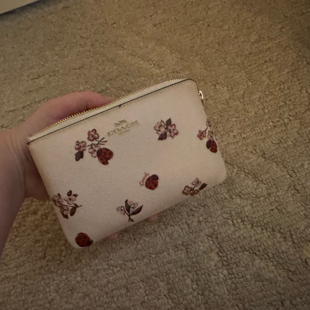Barely used coach wallet has ladybugs and flowers as the design